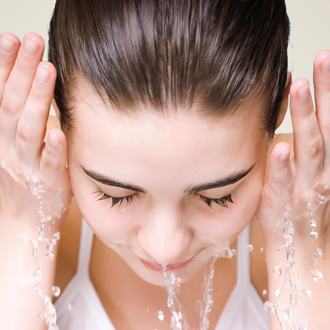 junge Frau wäscht sich Gesicht