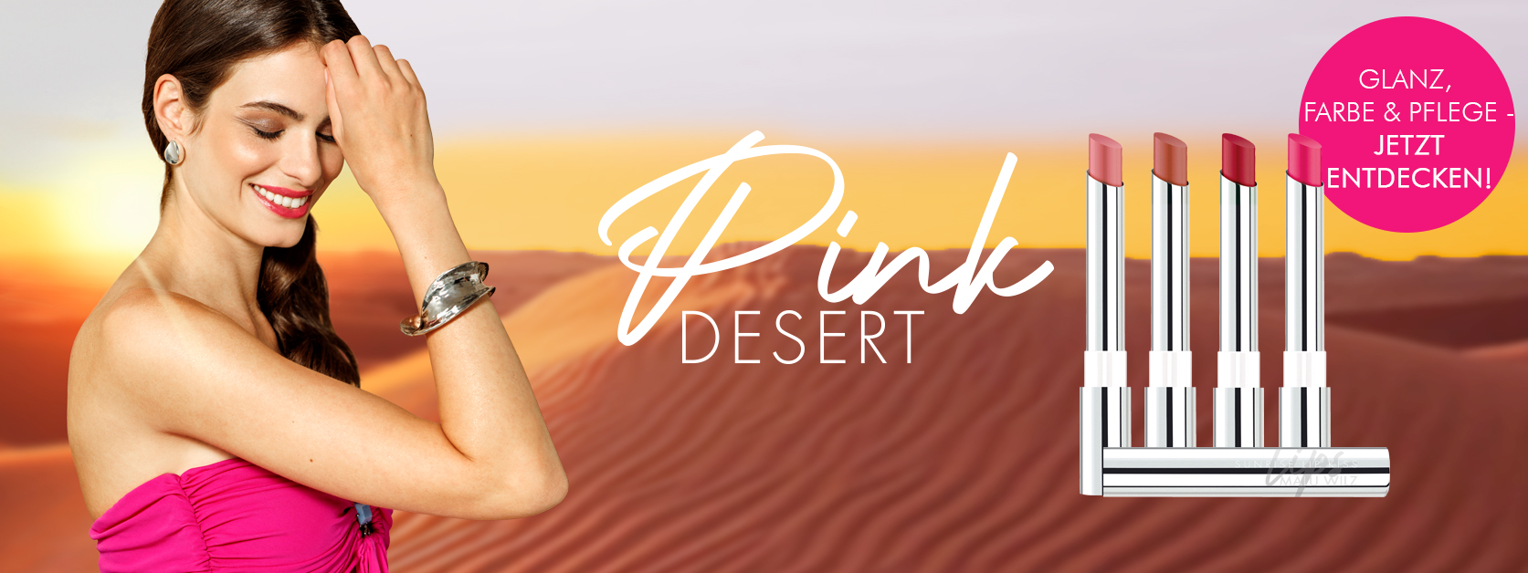 Frau mit braunen Haaren und pinken Lippen im pinken Kleid vor W&uuml;ste