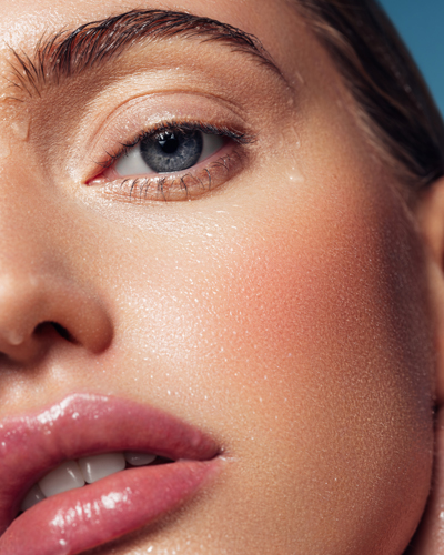 Close-up of a woman with water droplets on her face