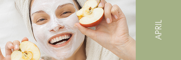 Juicy Apple Treatment junge Frau mit Gesichtsmaske und Äpfeln in den Händen