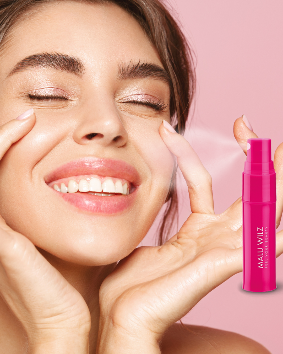 Frau h&auml;lt sich H&auml;nde ans Gesicht, rosa Hintergrund, pinker Ampullenspr&uuml;her