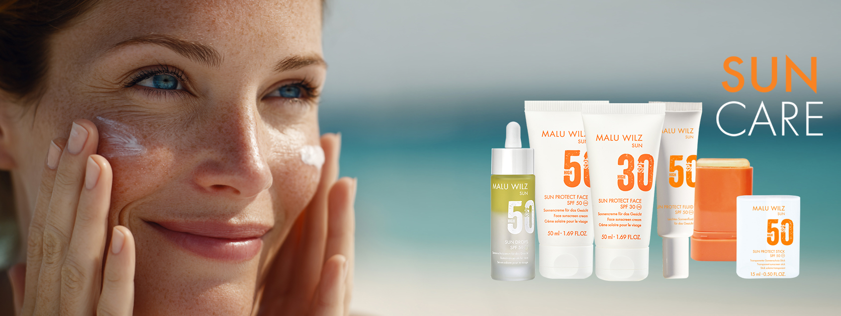 Frau cremt sich das Gesicht mit Sonnencreme ein