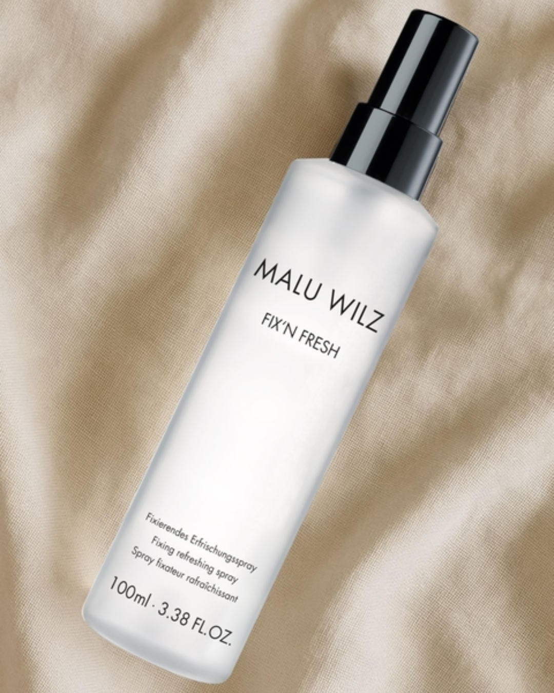 Langanhaltendes Make-up mit Fixing Spray Fixing Spray von Malu Wilz auf beigem Stoffhintergrund