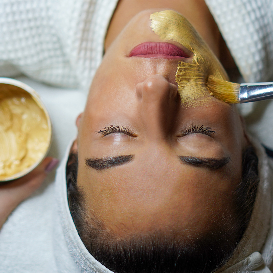 Junge Frau mit goldener Maske