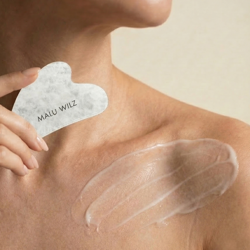 Decollete Frau mit Creme und in der Hand ein Gua Sha Stein