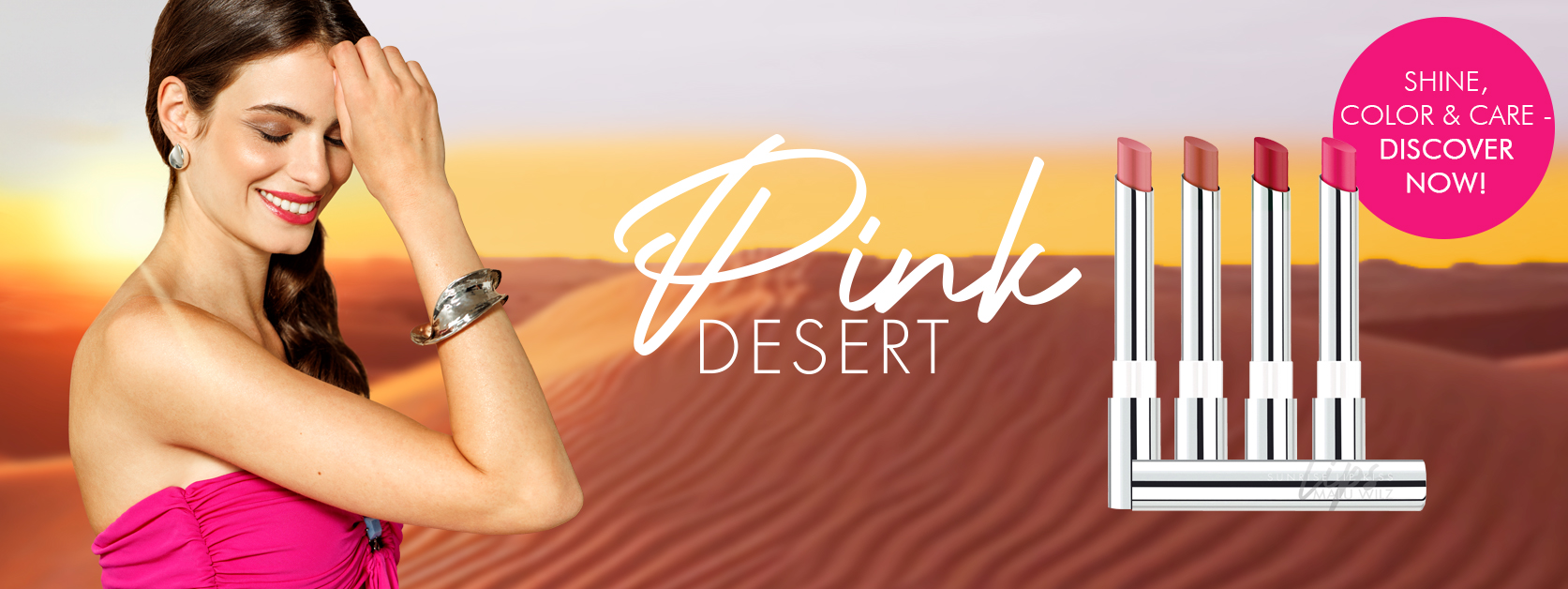 Woman with brown hair and pink lips in a pink dress in front of a desert