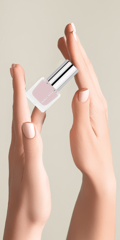 Hand mit beige-rosa Fingernägeln und Nagellack